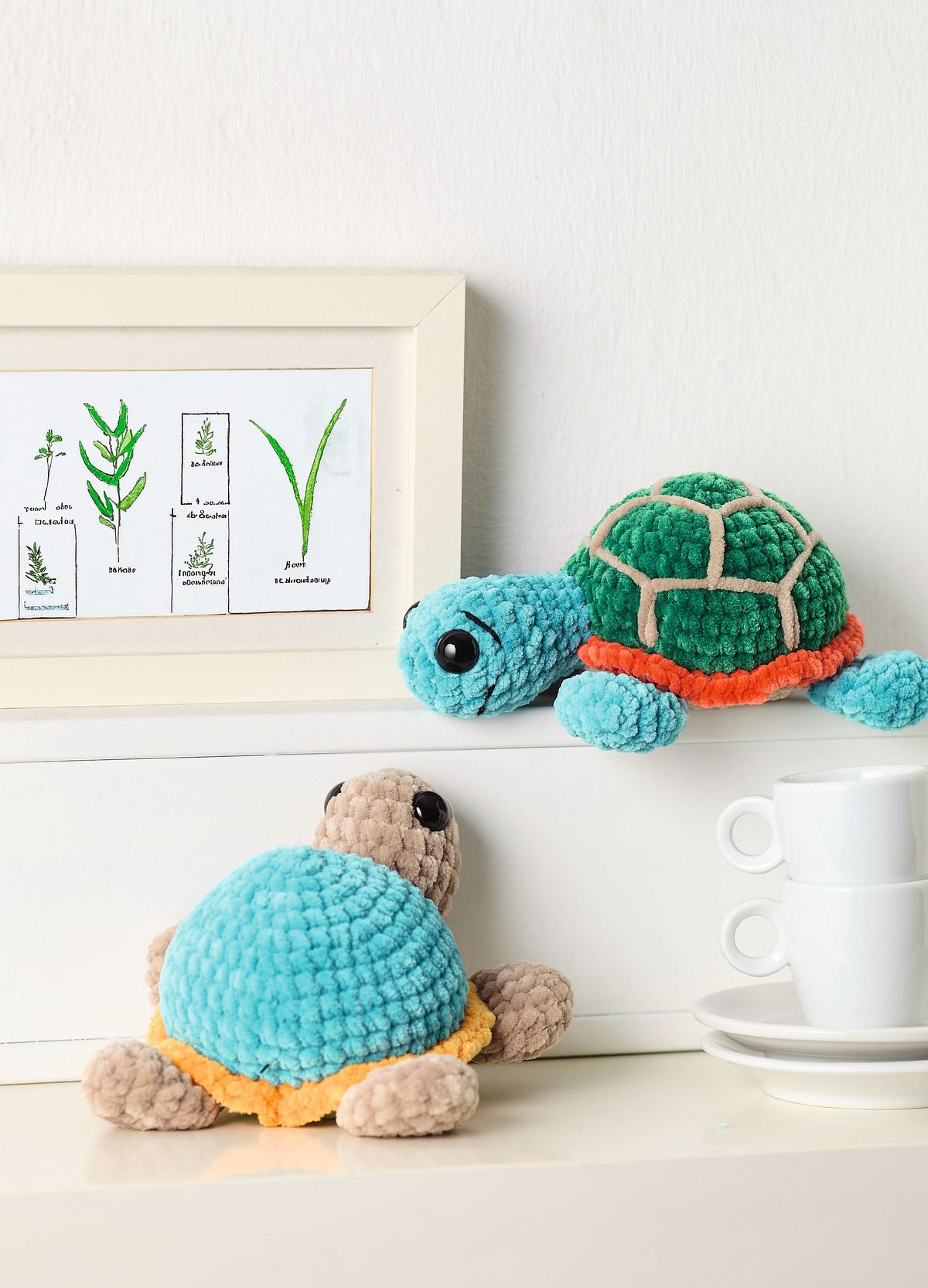 Zwei gehäkelte Schildkröten, die auf einem Regal stehen und sich angucken.