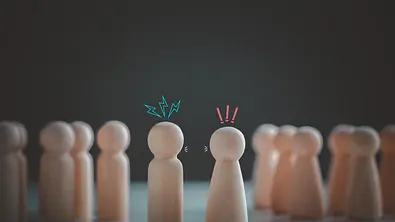 Symbolbild Konflikt- oder Meinungsverschiedenheitskonzept. Hölzerne Spielfiguren, die sich streiten - Foto: KTStock/iStock