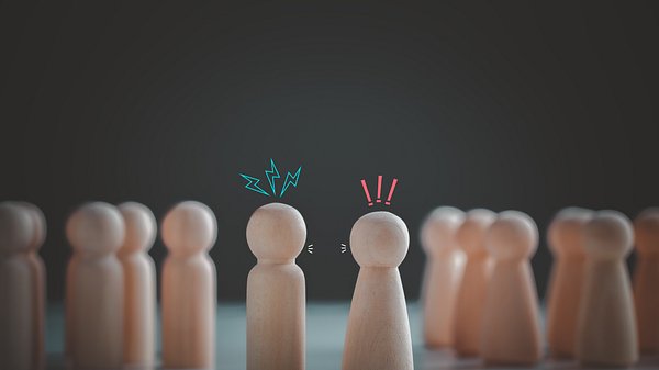 Symbolbild Konflikt- oder Meinungsverschiedenheitskonzept. Hölzerne Spielfiguren, die sich streiten - Foto: KTStock/iStock