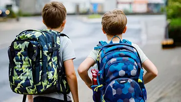 Zwei Jungs mit Schulranzen laufen eine Straße entlang (Themenbild) - Foto: romrodinka/iStock Zwei Jungs mit Schulranzen laufen eine Straße entlang (Themenbild) - Foto: romrodinka/iStock