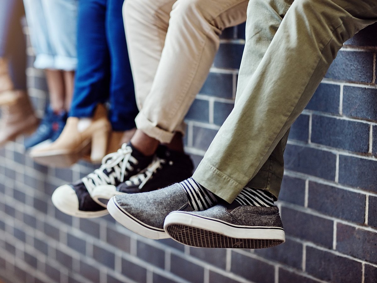 Jungs sitzen auf Erhöhung und tragen Schulschuhe für Jungen