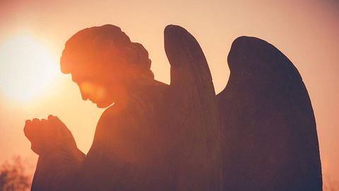 Ein steinerner Engel erstrahlt im Licht der aufgehenden Sonne. - Foto: umbertoleporini/iStock (Themenbild)