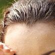 Schweißperlen auf der Stirn einer braunhaarigen Frau (Themenbild) - Foto: mediaphotos/iStock