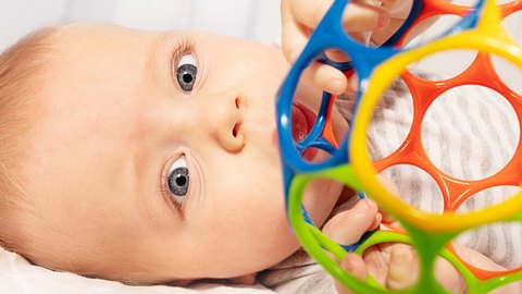 Kind mit Sensorik-Bällen fürs Baby - Foto: iStock/SerrNovik