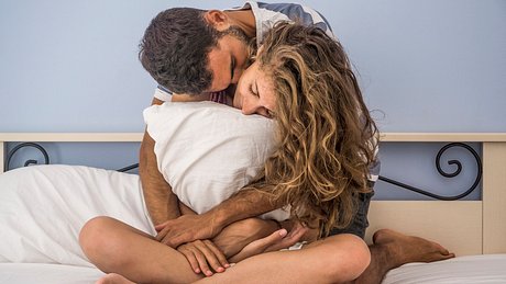 Mann und Frau kuscheln im Bett - Foto: Carlo107/iStock