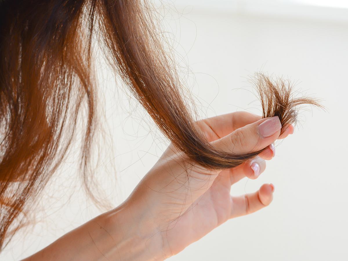 Frau nutzt Shampoo für trockenes Haar