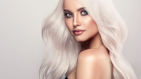 Foto einer Frau mit hellem blonden Haar, das silber glänzt - Foto: iStock/Sofia Zhuravets