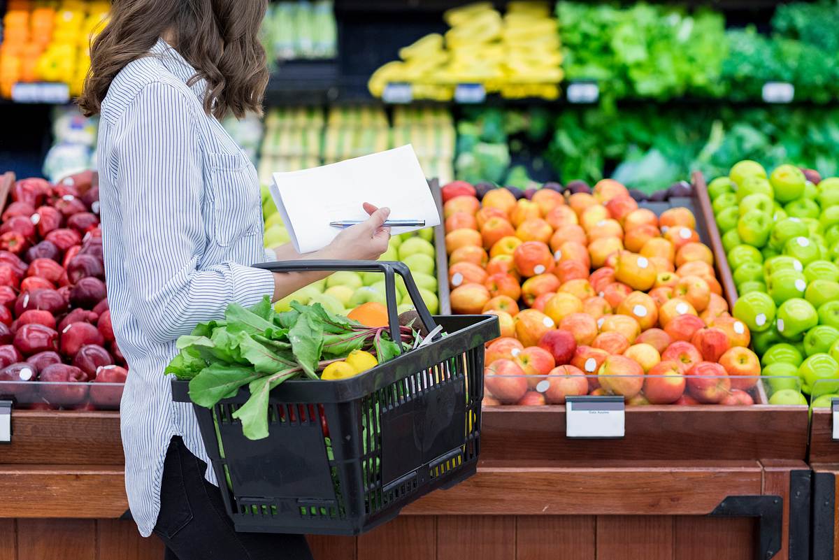 Nicht erkennbare Frau kauft im Supermarkt ein.