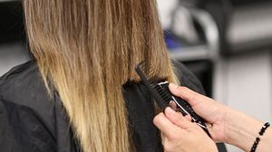 Das lange Haar einer Frau wird geschnitten. - Foto: Ivan-balvan/iStock (Themenbild)