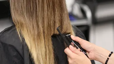 Das lange Haar einer Frau wird geschnitten. - Foto: Ivan-balvan/iStock (Themenbild) Das lange Haar einer Frau wird geschnitten. - Foto: Ivan-balvan/iStock (Themenbild)