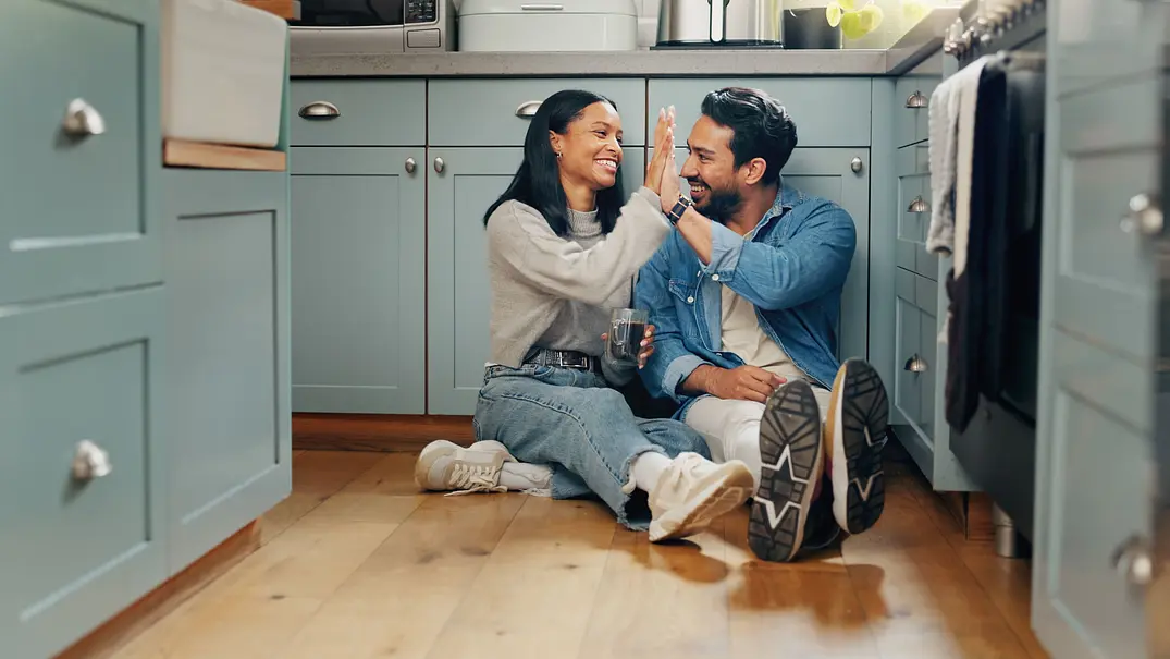 Ein heterosexuelles Paar sitzt auf dem Küchenbogen und lächelt sich an. - Foto: Jacob Wackerhausen / iStock Ein heterosexuelles Paar sitzt auf dem Küchenbogen und lächelt sich an. - Foto: Jacob Wackerhausen / iStock