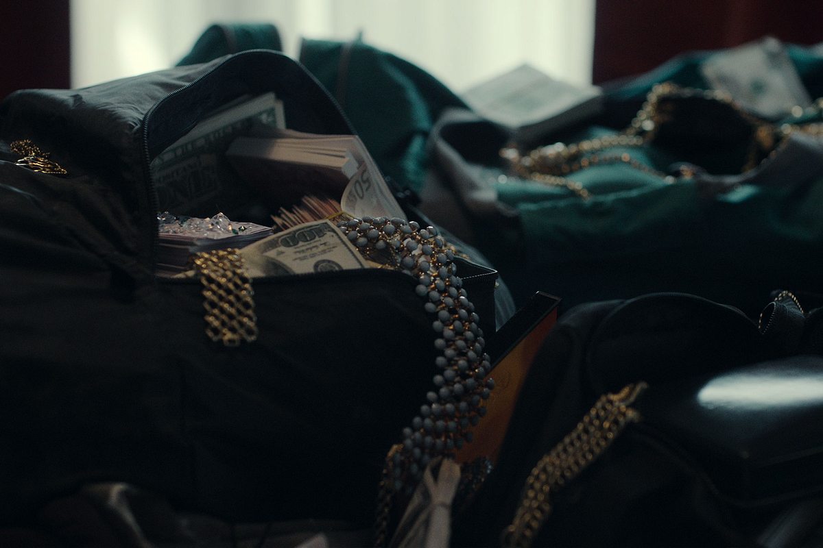 Taschen überfüllt mit Schmuck, Diamanten und Geldbündeln. 