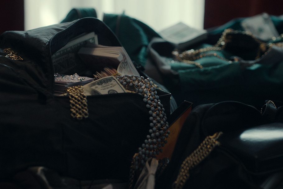 Taschen überfüllt mit Schmuck, Diamanten und Geldbündeln. 