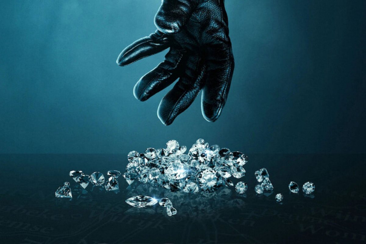 Hand in schwarzem Lederhandschuh greift nach Diamanten.