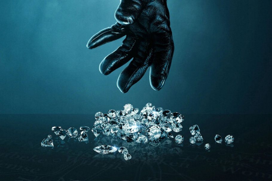 Hand in schwarzem Lederhandschuh greift nach Diamanten.