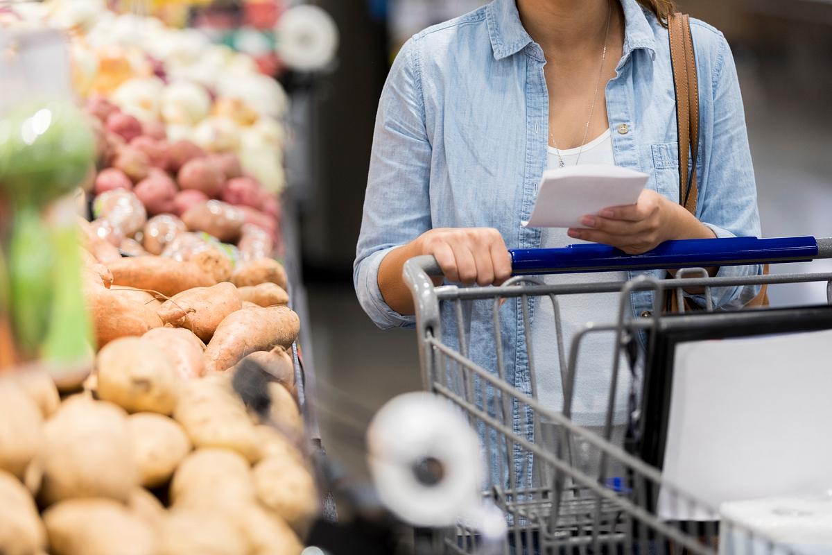 Nicht erkennbare Frau schaut sich Produkte im Supermarkt an.