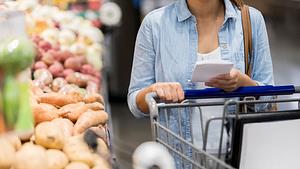 Nicht erkennbare Frau schaut sich Produkte im Supermarkt an. - Foto: SDI Productions/iStock