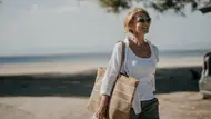 Frau in weißer Bluse geht am Strand. - Foto: iStock/freemixer Frau in weißer Bluse geht am Strand. - Foto: iStock/freemixer