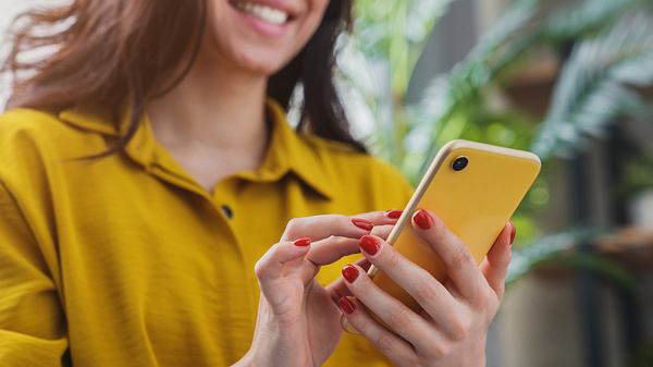 Frau hält Smartphone in der Hand. - Foto: Inside Creative House/iStock