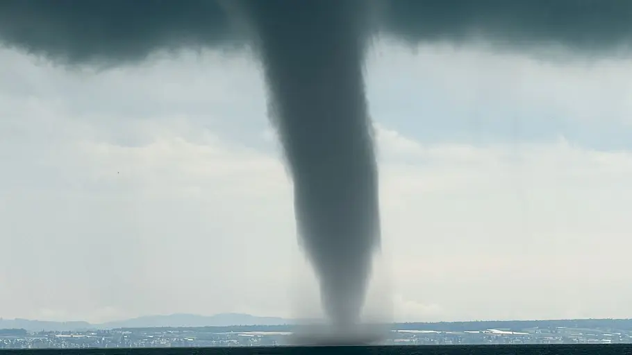 Tornado über dem Bodensee Eine dunkle Wasserhose zieht über den Bodensee und wirbelt Wasser unter einer Gewitterwolke auf.