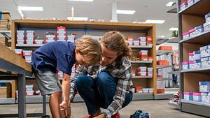 Mutter und Sohn kaufen Schuhe - Foto: Juanmonino/iStock