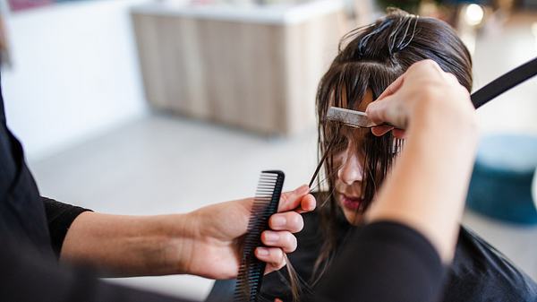 Frau werden Haare beim Friseur geschnitten (Themenbild) - Foto: iStock/Kosamtu