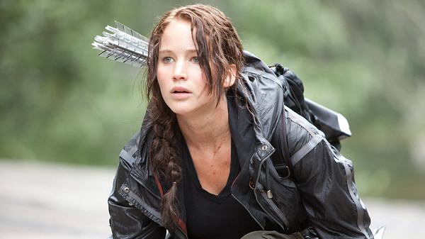Katniss Everdeen, gespielt von Jennifer Lawrence, kniet auf dem Boden und hat einen Köcher mit Pfeilen geschultert (Themenbild) - Foto: IMAGO / Cinema Publishers Collection