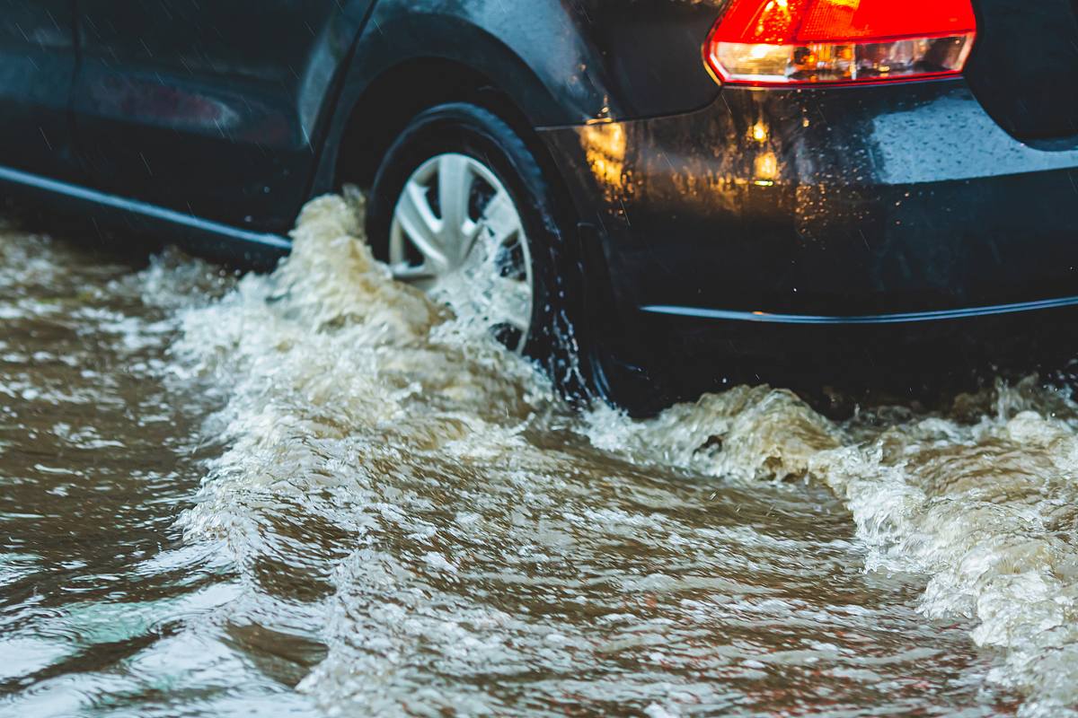 Auto fährt durch Hochwasser.