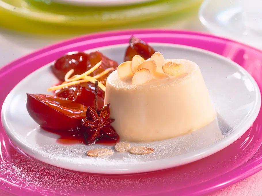 Panna Cotta mit Mandelblättchen, Pflaumen und Sternanis garniert.