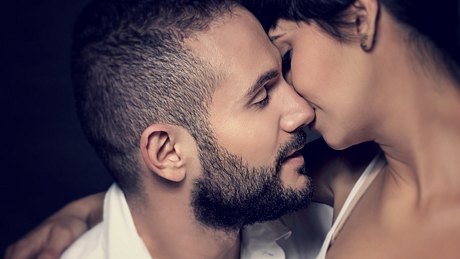 Closeup portrait of gentle loving couple kissing isolated on black background, enjoying romantic relationship, affection and tenderness concept - Foto: Anna_Om/iStock