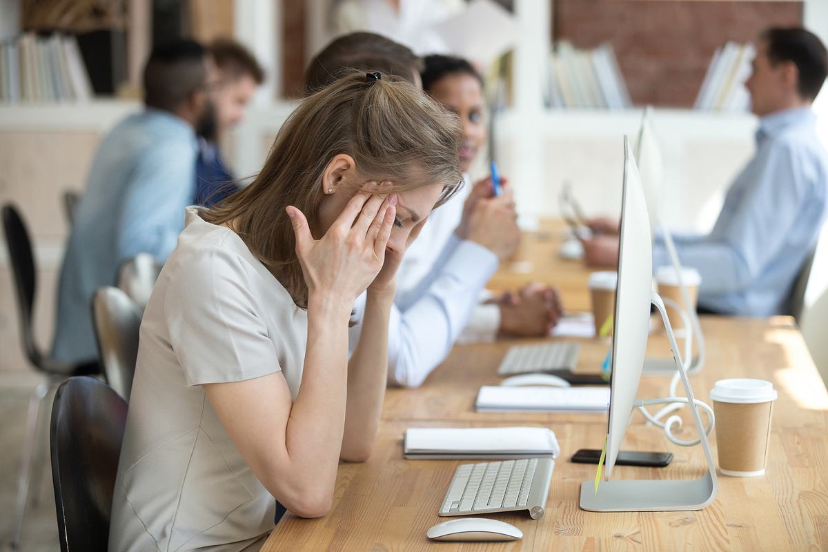 Frau vor Computer massiert sich die Schläfen (Themenbild)