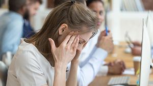 Frau vor Computer massiert sich die Schläfen (Themenbild) - Foto: fizkes/iStock