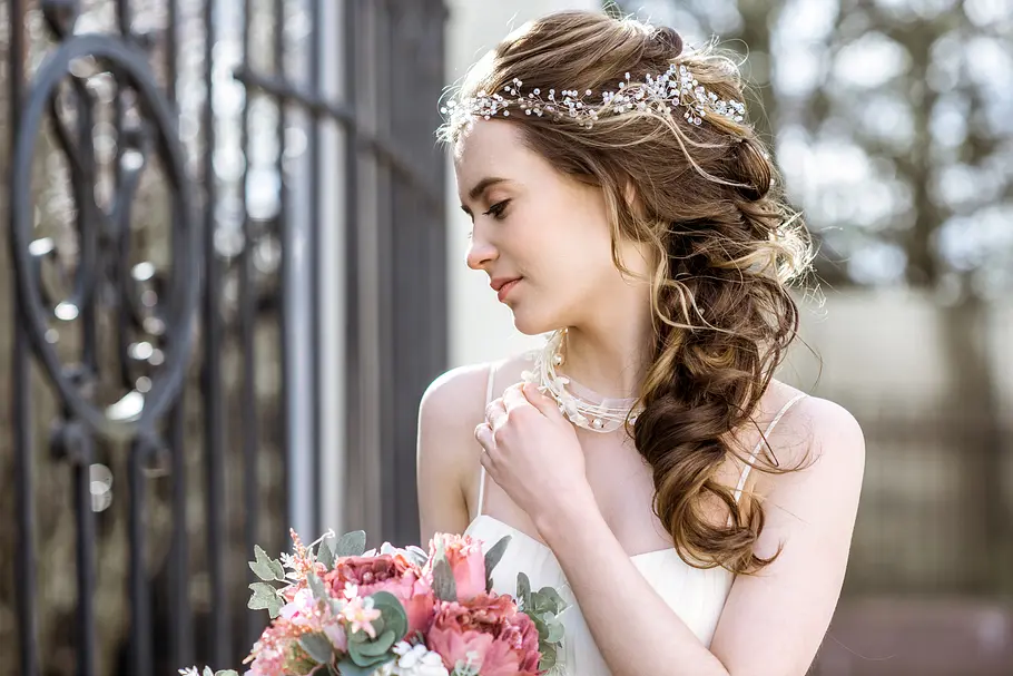 Braut mit lockerem Bauernzopf und kleinem Blumenkranz