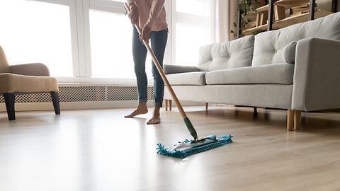 Frau trägt den Vinylboden-Reiniger auf - Foto: iStock/fizkes