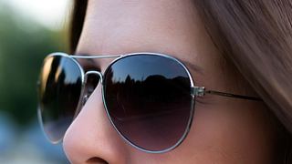 Nahaufnahme einer nicht erkennbaren Frau mit Sonnenbrille. - Foto: milicad/iStock