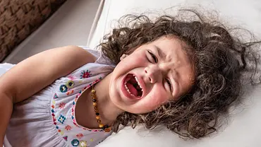 Mädchen liegt auf dem Bett und schreit. - Foto: iStock/mofles