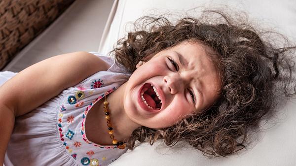 Mädchen liegt auf dem Bett und schreit. - Foto: iStock/mofles