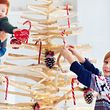 Weihnachtsbaum aus Holz - die Familie schmückt ihn - Foto: iStock/olesiabilkei