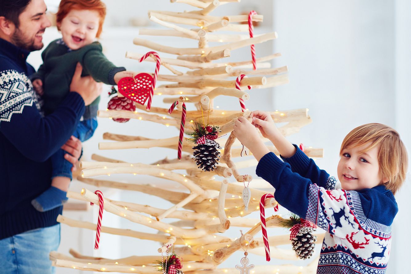 Weihnachtsbaum aus Holz - die Familie schmückt ihn