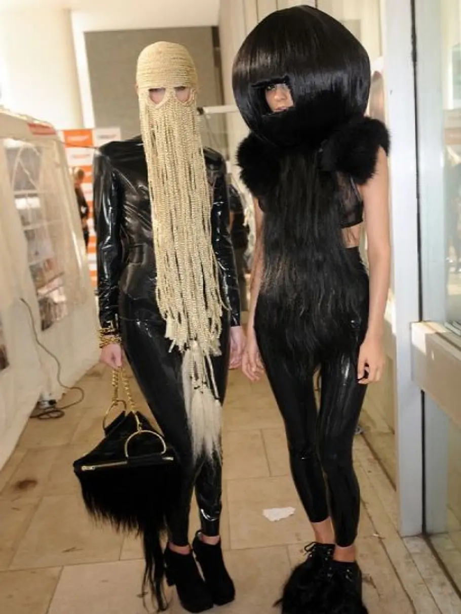 Wer sagt eigentlich, dass Haare nur auf den Hinterkopf gehören? Models mit einer verrückten Frisur, bei der die Haare auch über das Gesicht gelegt werden.