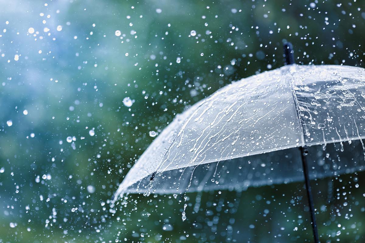 Durchsichtiger Regenschirm, auf den eine enorme Menge Regen prasselt.