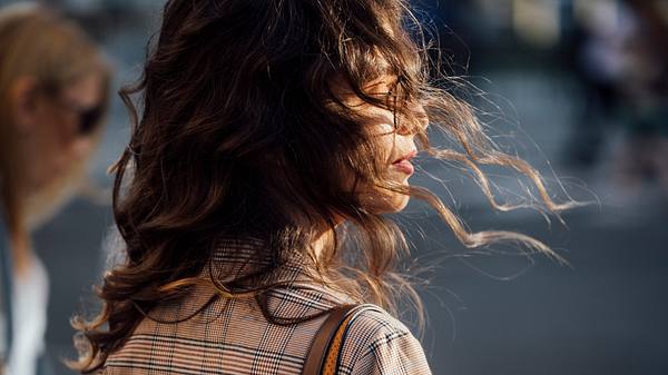 Frau mit braunen langen Haaren im Wind (Themenbild)  - Foto: FreshSplash/iStock