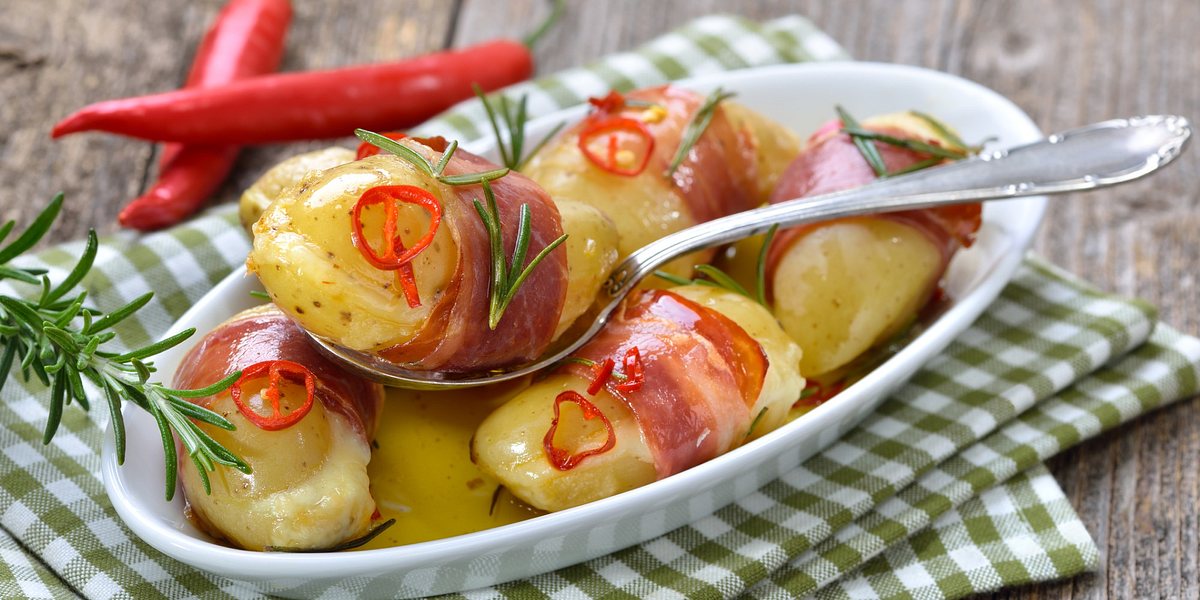 Mit Käse gefüllte Rosmarinkartoffeln im Schinkenmantel