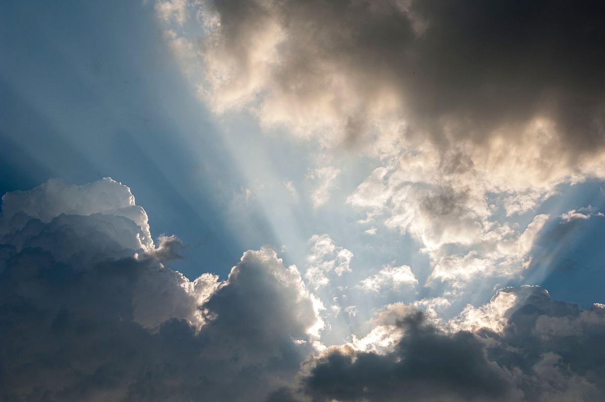 Sonnenstrahlen der verdeckten Sonne bahnen sich ihren Weg durch die Wolkendecke