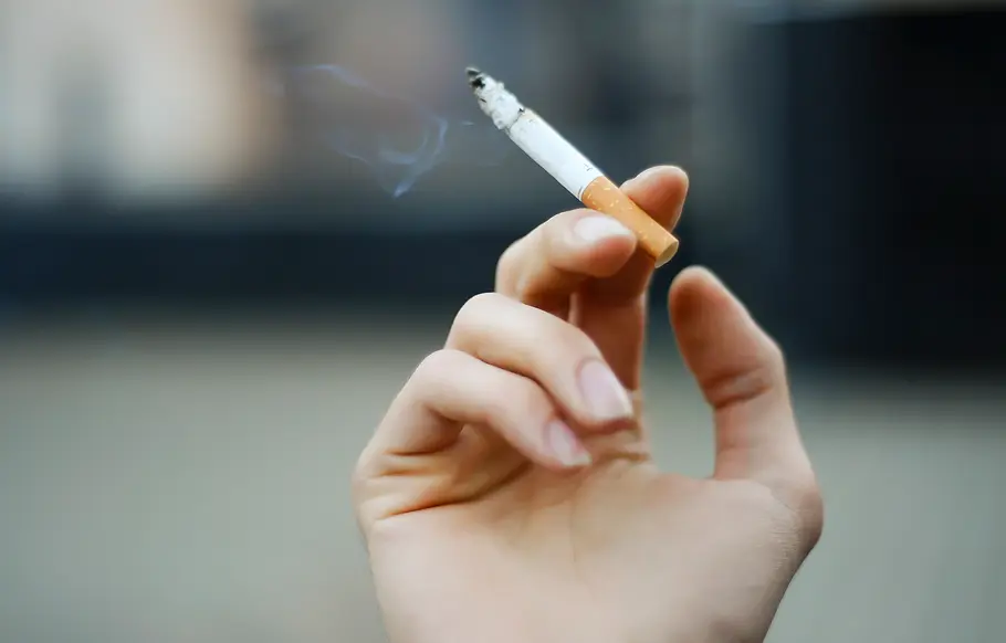 Zigaretten-Preise explodieren: So teuer wird es jetzt für Raucher in Deutschland! Brennende Zigarette in einer Frauenhand.