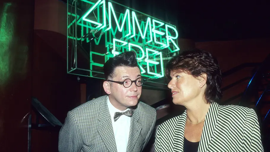 Götz Alsmann und Christine Westermann. Götz Alsmann und Christine Westermann vor dem „Zimmer frei“-Leuchtschild.